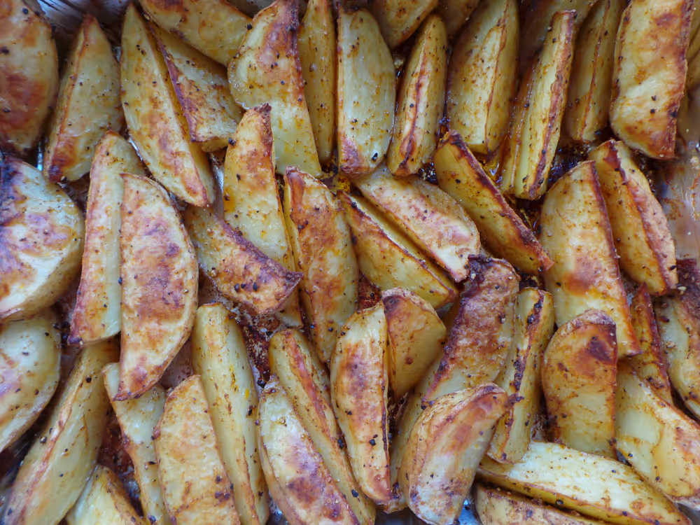 Potato wedges on baking tray