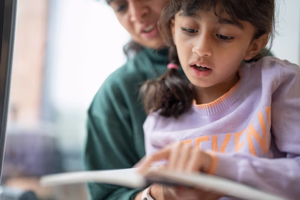 Girl reading a book with her mum